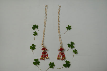 Pair of red and gold beaded earrings on a white background