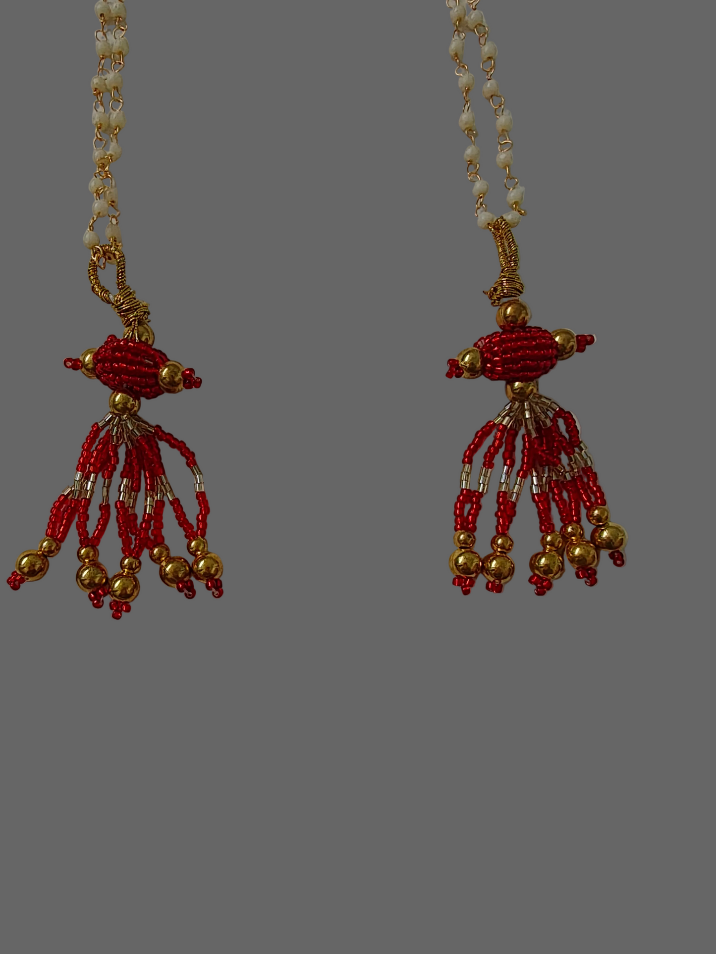 Beaded necklace with red and gold beads on a white background