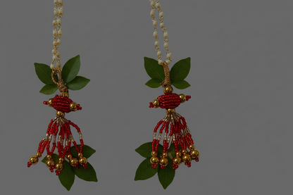 Pair of decorative earrings with red and gold beads on a gray background