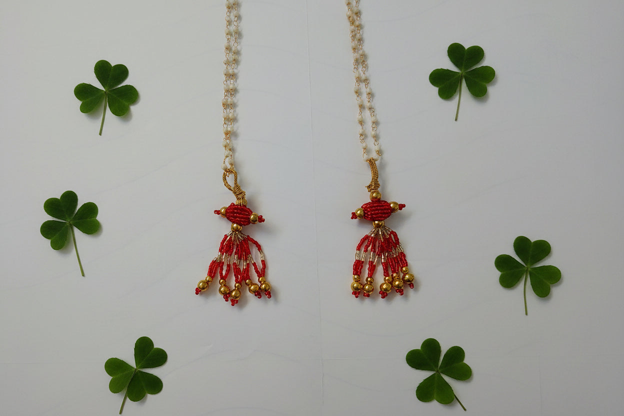 Beaded necklace with red and gold beads on a white background
