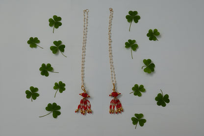 Decorative hair accessory with red and gold elements on a gray background