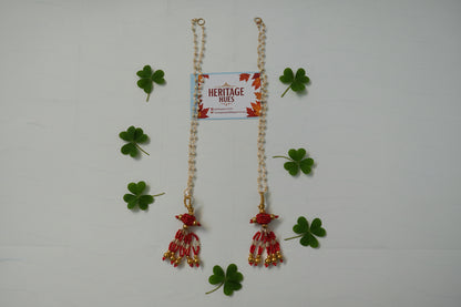 Bracelet with red and gold floral charms on a white background, featuring a 'Heritage Hues' card.