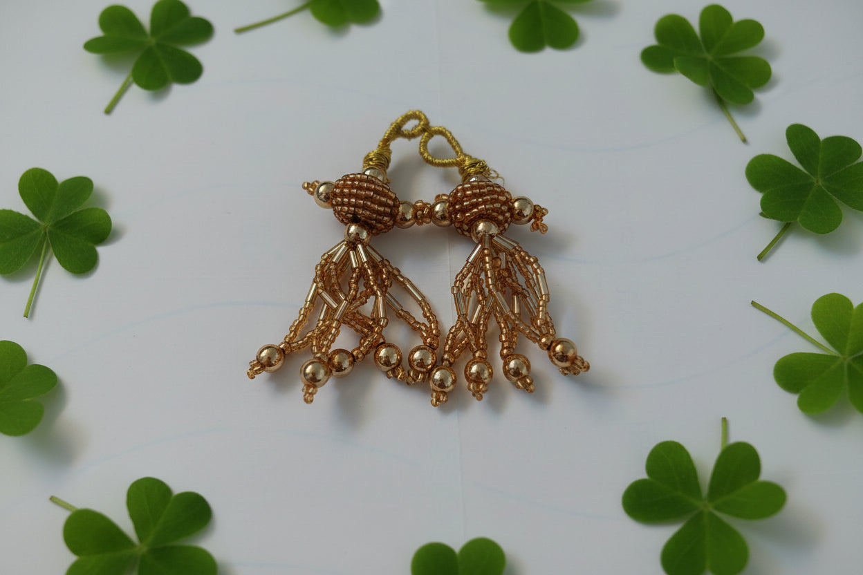 Gold beaded butterfly accessory on a light gray background