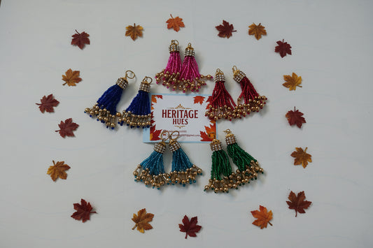 Colorful tassel decorations with a 'Heritage Hues' card on a light gray background