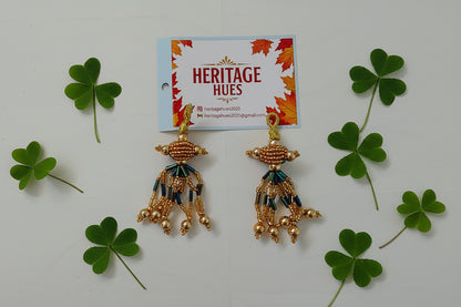Gold earrings with intricate designs on a white background, next to a 'Heritage Hues' card.