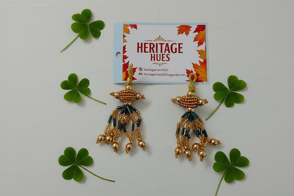 Gold earrings with blue accents on a white background, next to a 'Heritage Hues' card.