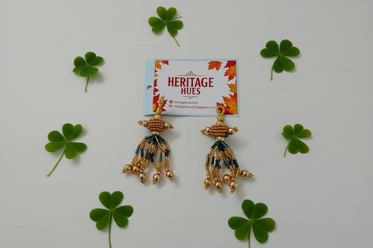 Gold earrings with blue accents on a white background, next to a 'Heritage Hues' card.