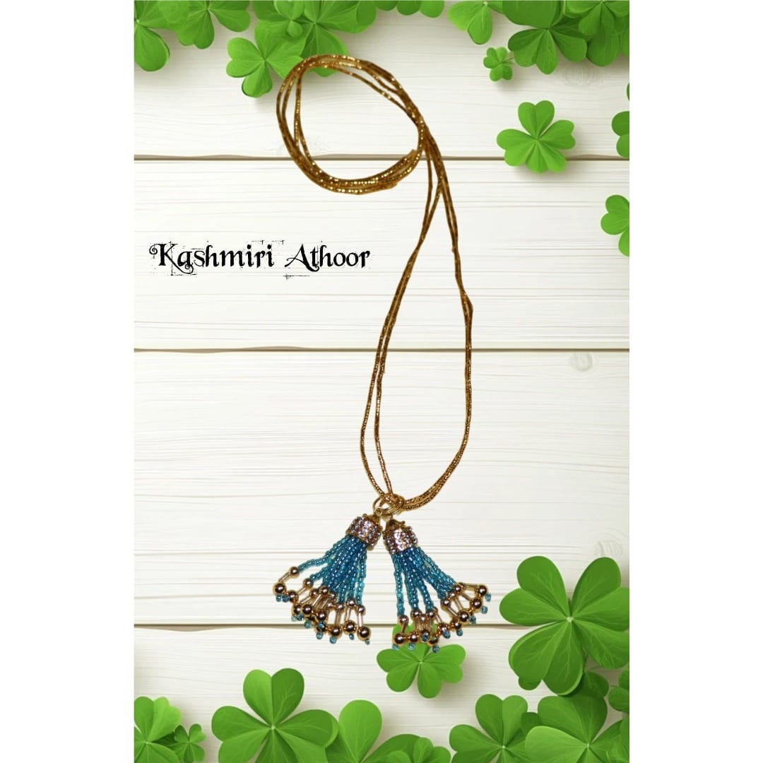 Necklace with blue and gold tassels on a white background with green shamrocks