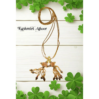 Gold necklace with pendant on a white background with green leaves