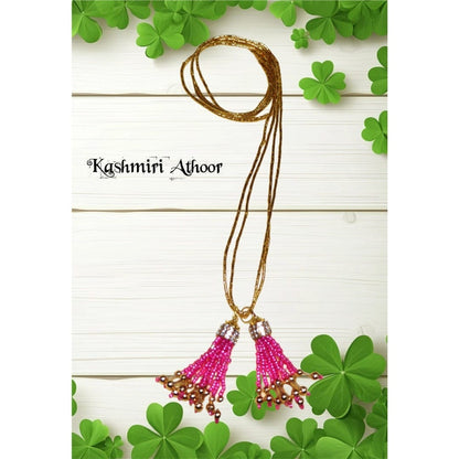 Gold necklace with pink pendants on a white background with green leaves